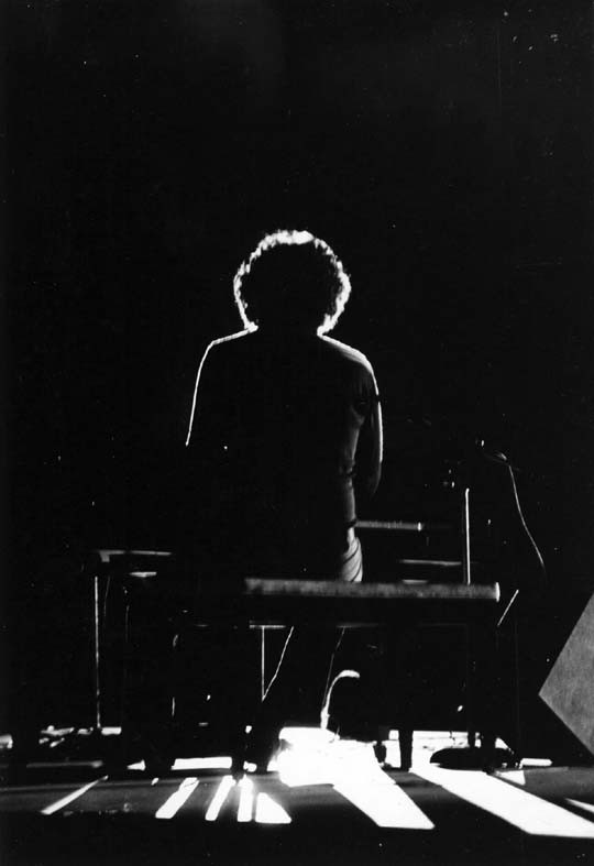 Backlit photo of Keith in concert, Twin Oaks Youth With A Mission base concert, Lindale Texas, 1981.